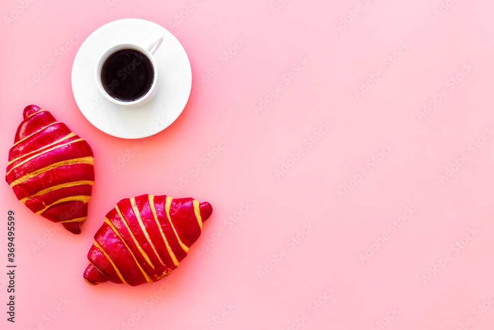 Coffee and croissants on pink background top view