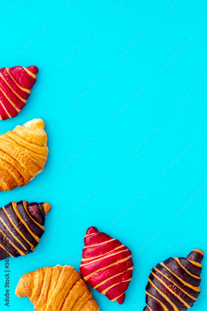 Set of croissants - chocolate, berry, classic - on blue table top view