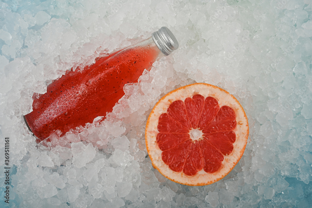 Bottle of red grapefruit drink on ice