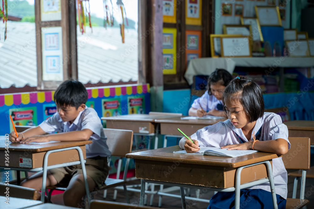 穿着制服的亚洲小学生在课堂上一起学习，教育，学生，人的概念