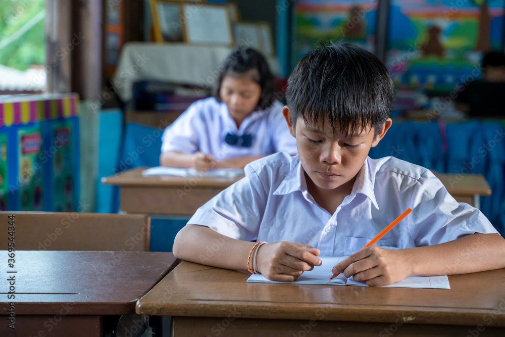 穿着制服的亚洲小学生在课堂上一起学习，教育，学生，人的概念