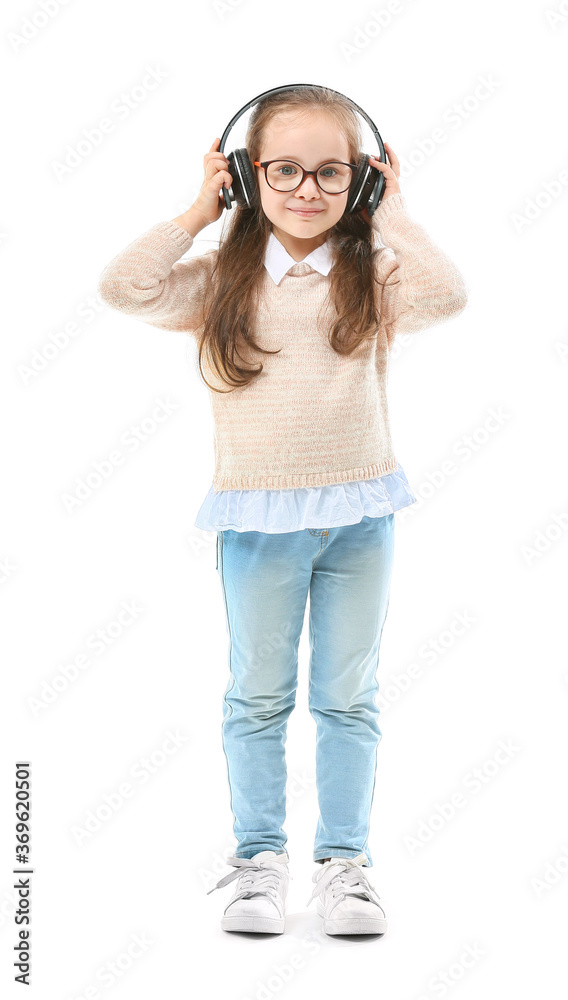 Cute little girl listening to music on white background