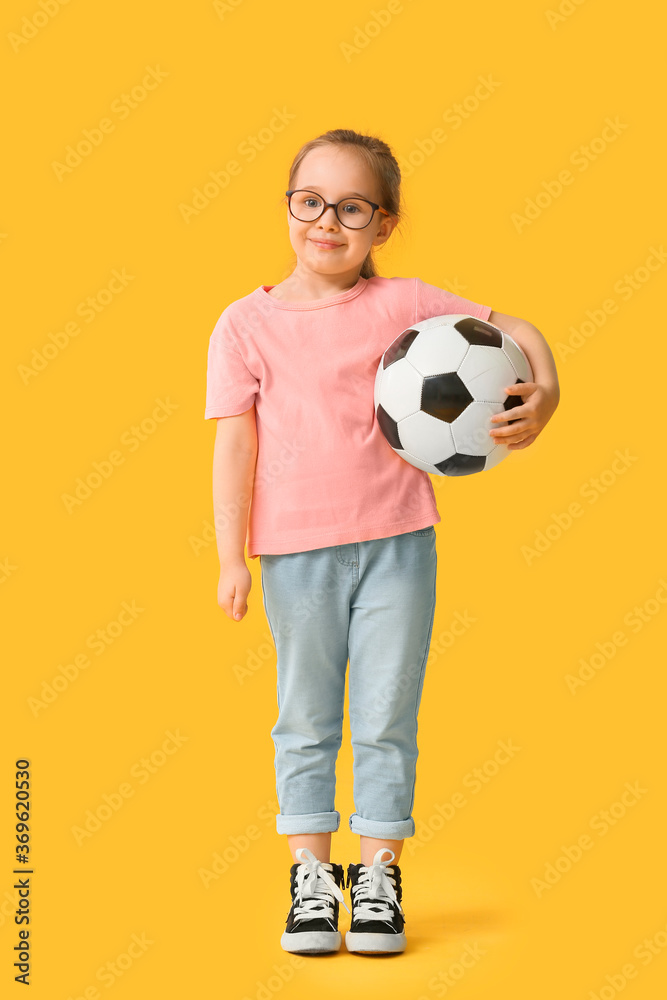 Cute little girl with soccer ball on color background