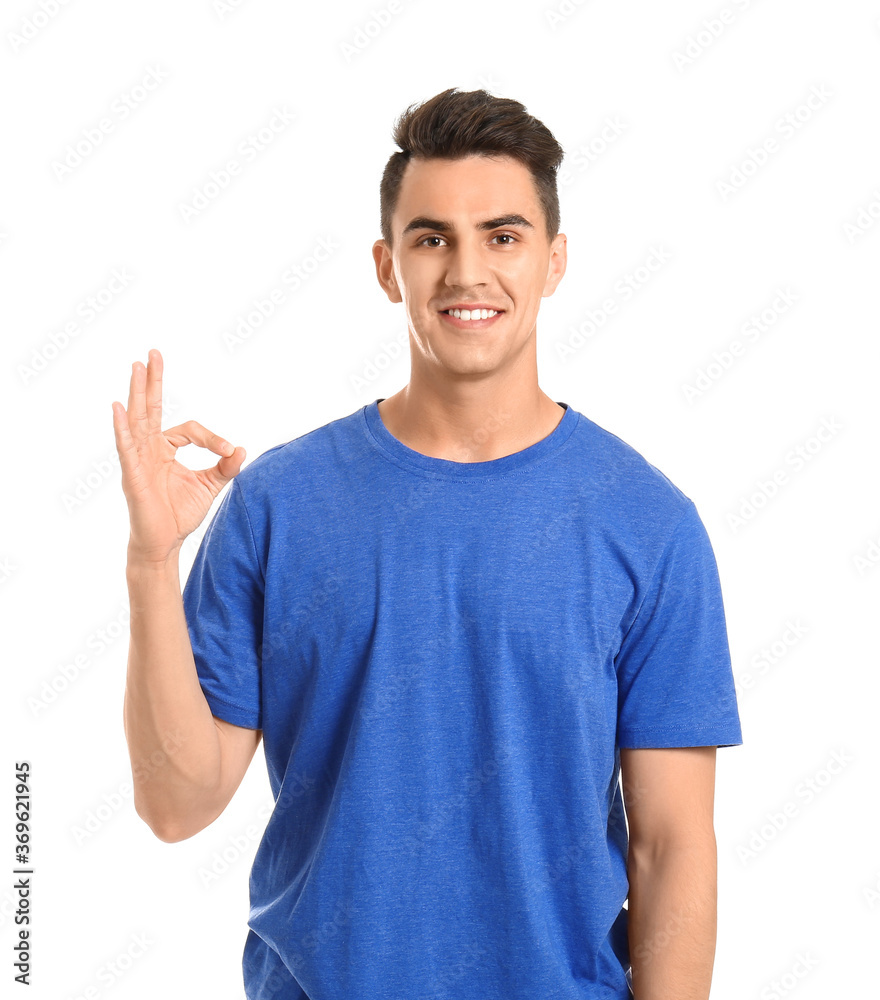 Handsome young man showing OK gesture on white background