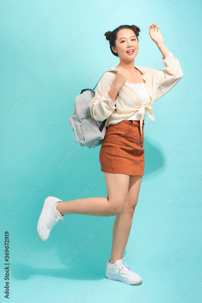 Funny cool cute beautiful girl posing against a white wall, bright casual wear, backpack