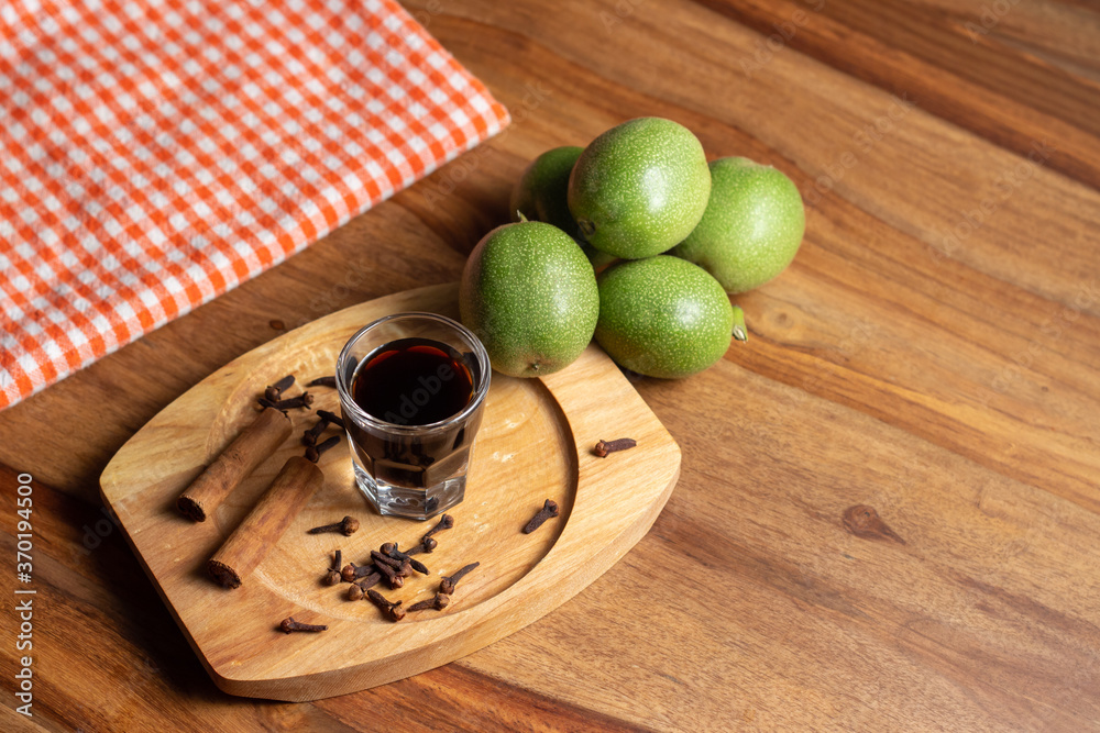 homemade nocino with green walnuts, cinnamon sticks and cloves.