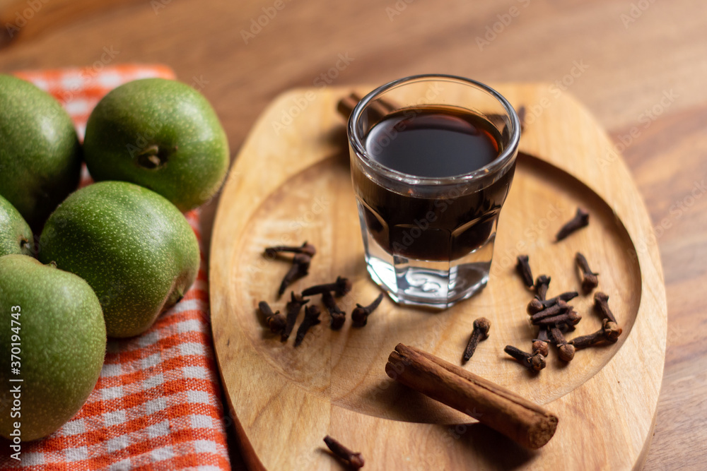 homemade nocino with green walnuts, cinnamon sticks and cloves.