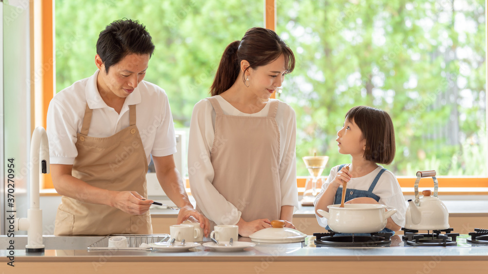 キッチンで料理を作る女の子と両親