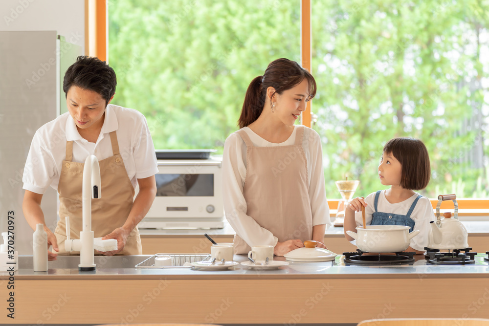 キッチンで料理を作る女の子と両親