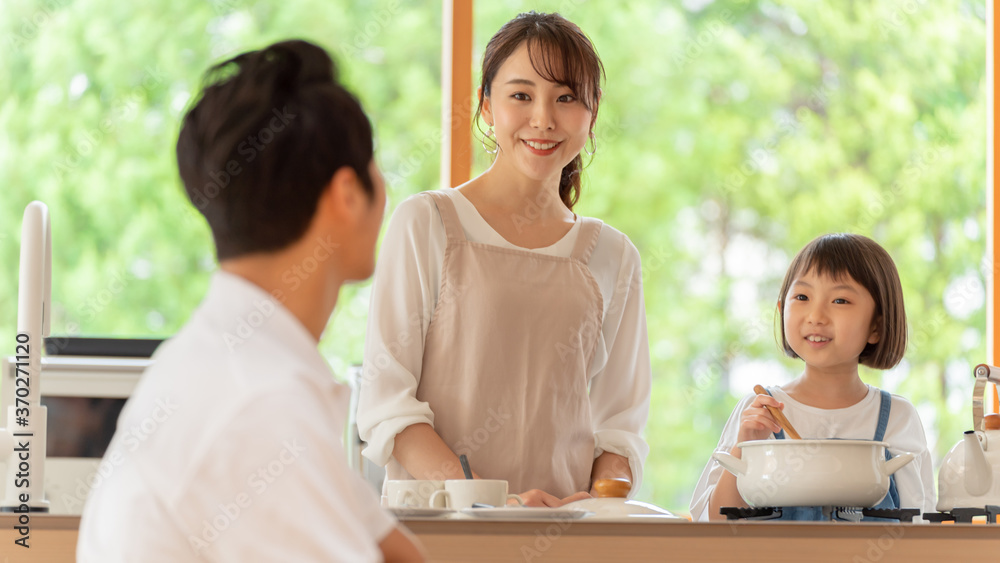 キッチンで料理を作る女の子と両親