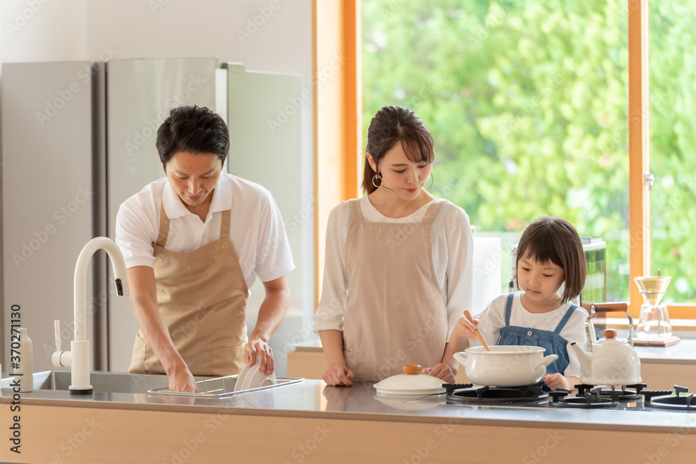 キッチンで料理を作る女の子と両親