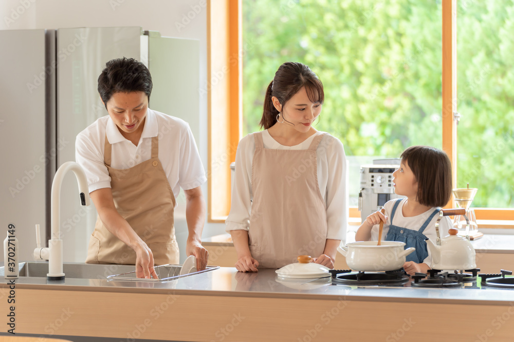 キッチンで料理を作る女の子と両親