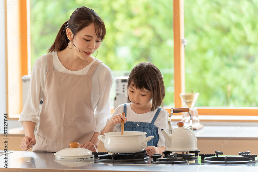 キッチンで料理を作る女の子と両親