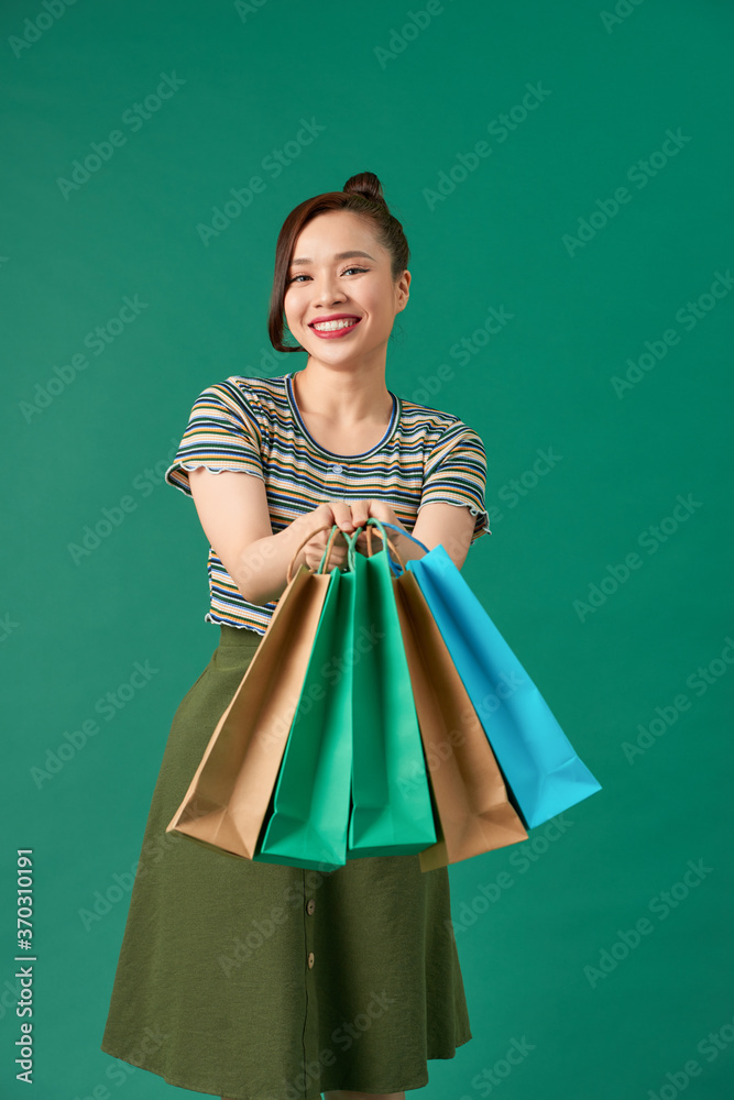 Stylish asian woman smiling and holding shopping bags