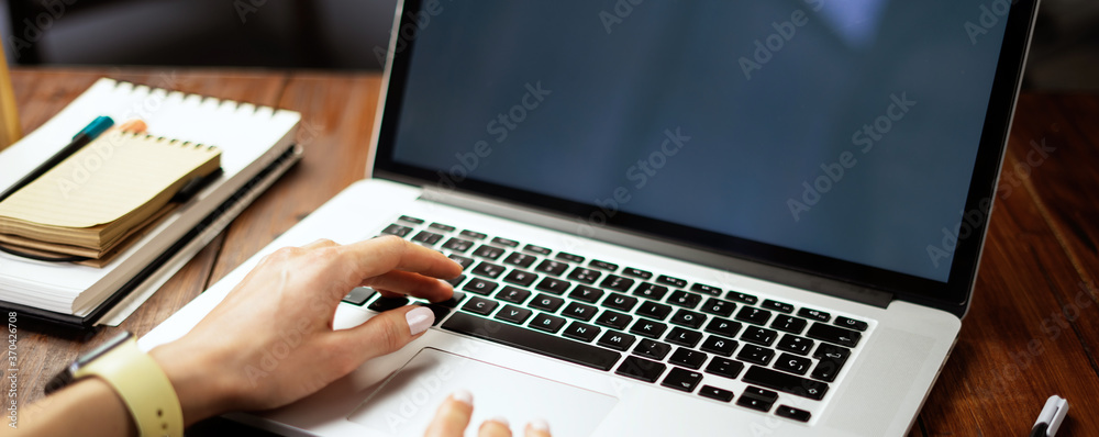 Closeup photo of female hands with a laptop. Female freelancer connecting to internet via computer. 