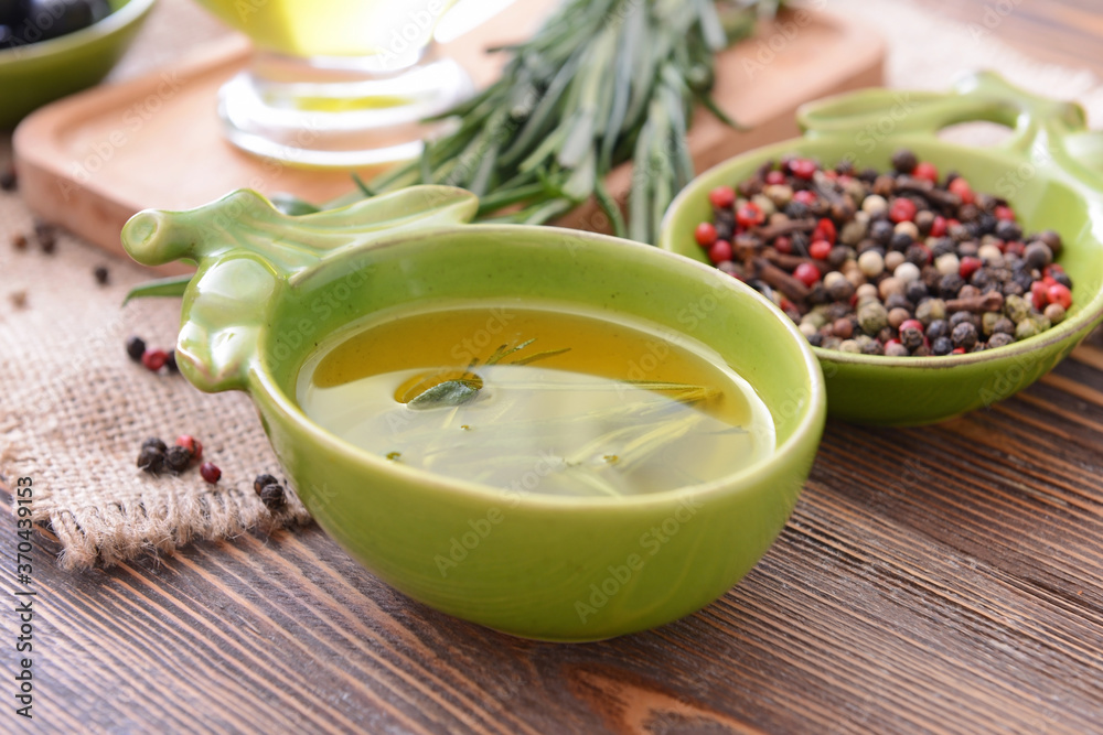 Bowl of rosemary oil and spices on table