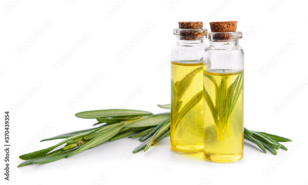 Bottles of rosemary essential oil on white background