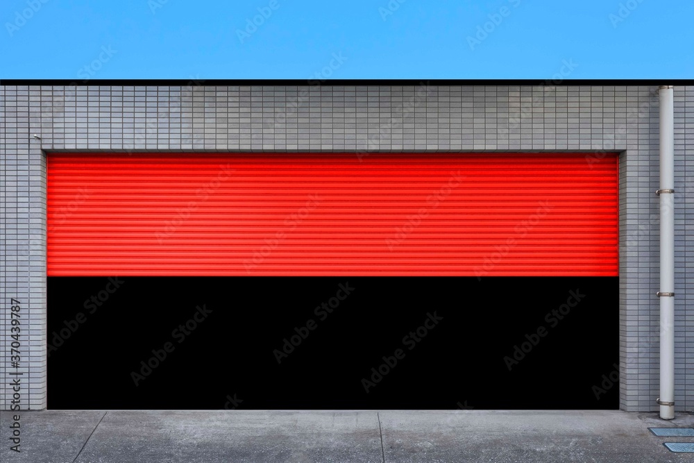 Red metal garage at the building that opens the door.