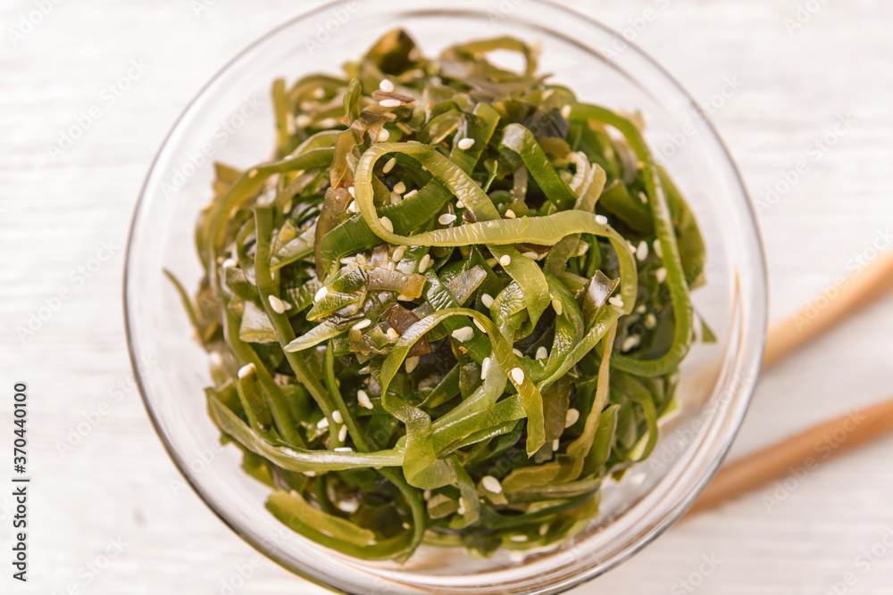 Bowl with tasty seaweed on table, closeup