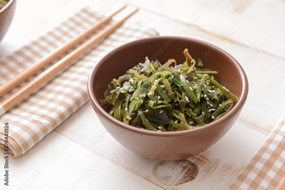 Bowl with tasty seaweed on table