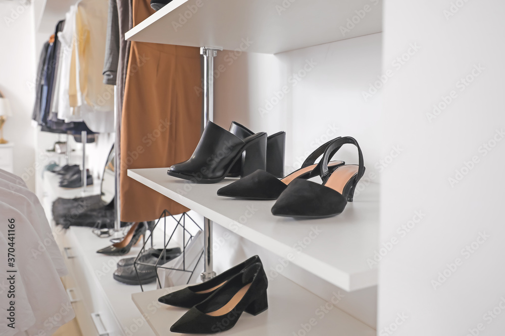 Shelves with stylish shoes in modern store