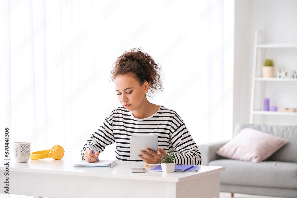 Young woman using tablet computer for online learning at home