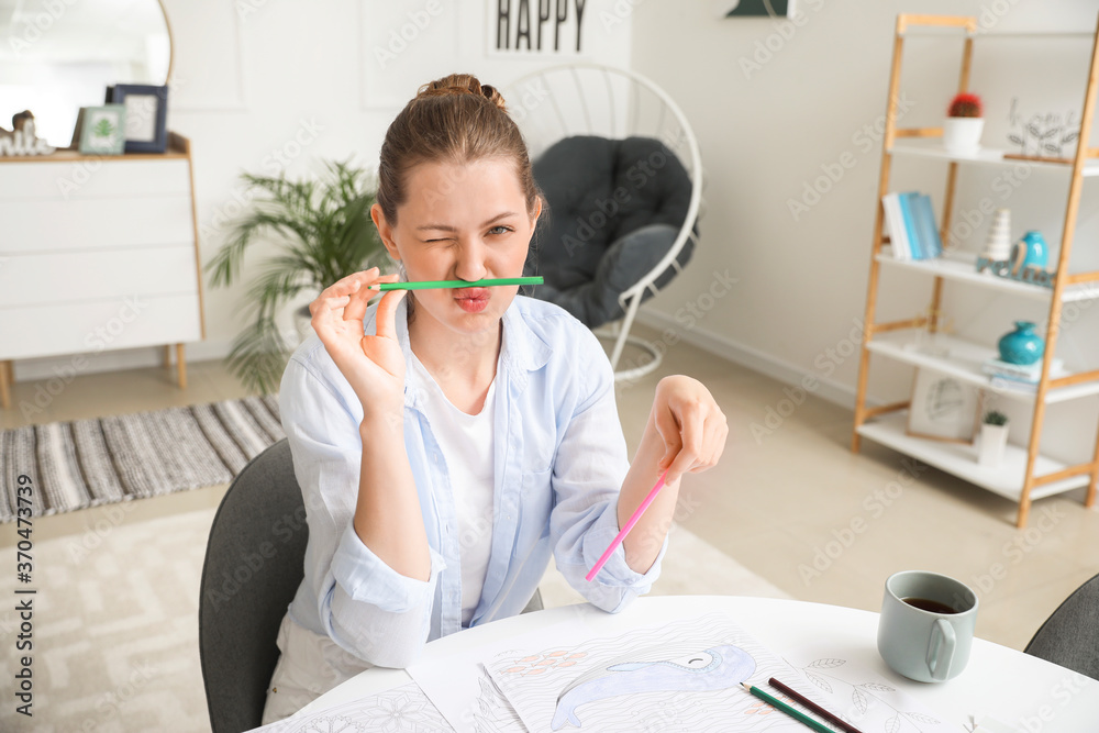 Funny woman coloring picture at home