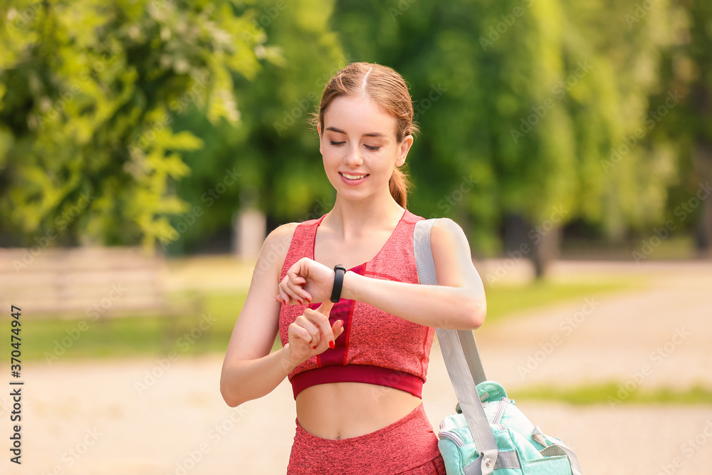 户外带健身追踪器的运动型年轻女性