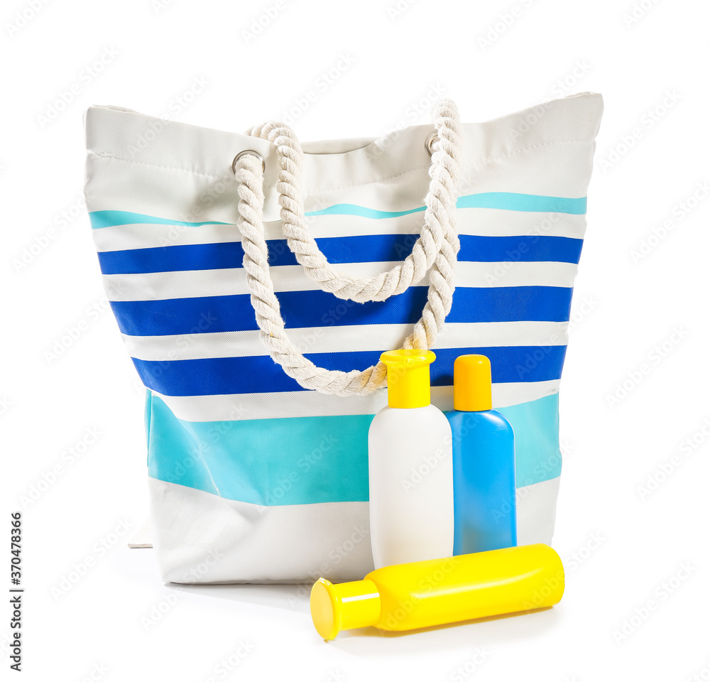 Beach bag with sunscreen cream on white background