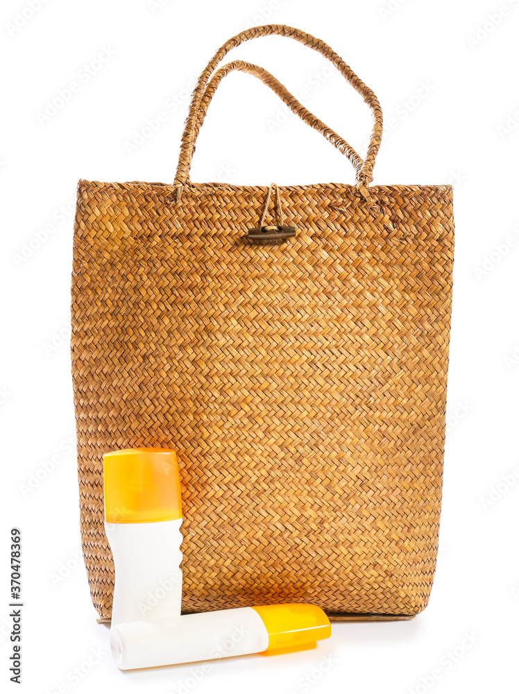 Beach bag with sunscreen cream on white background