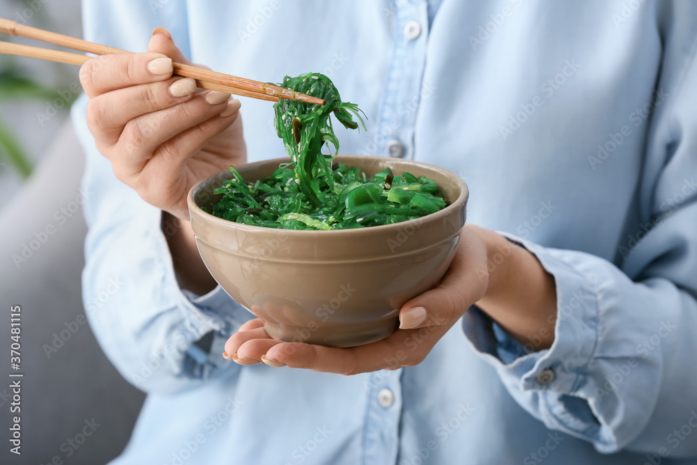 女人在吃美味的海藻沙拉，特写镜头