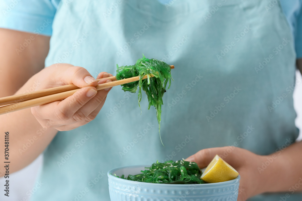 女人在吃美味的海藻沙拉，特写镜头