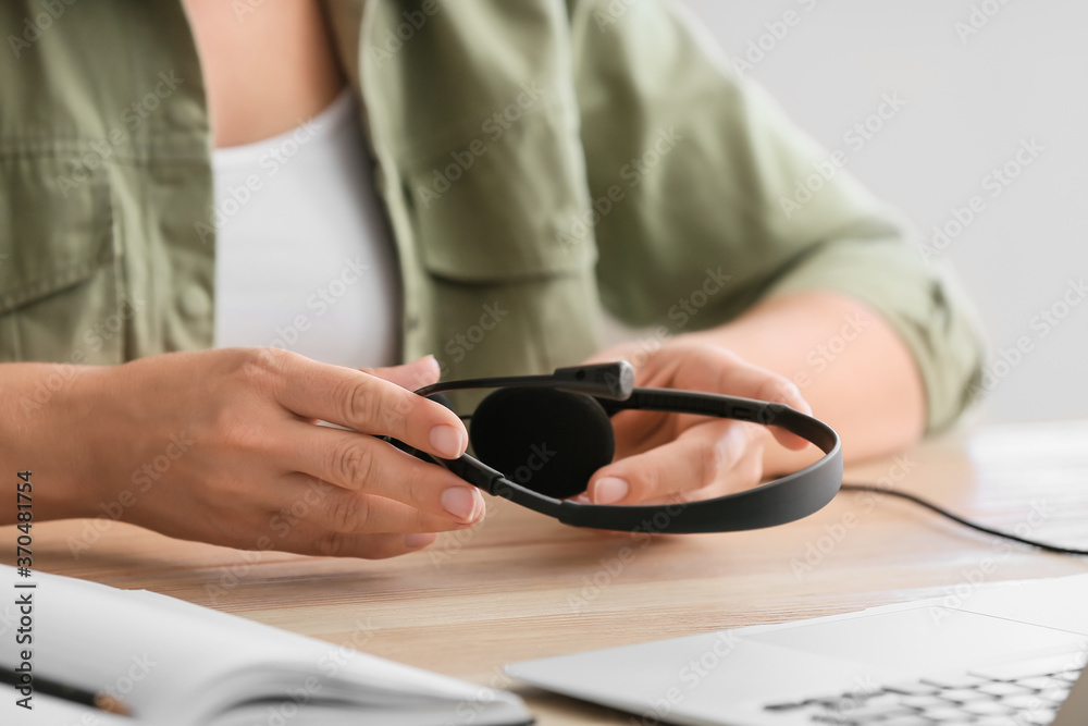 Woman with headset working in office, closeup