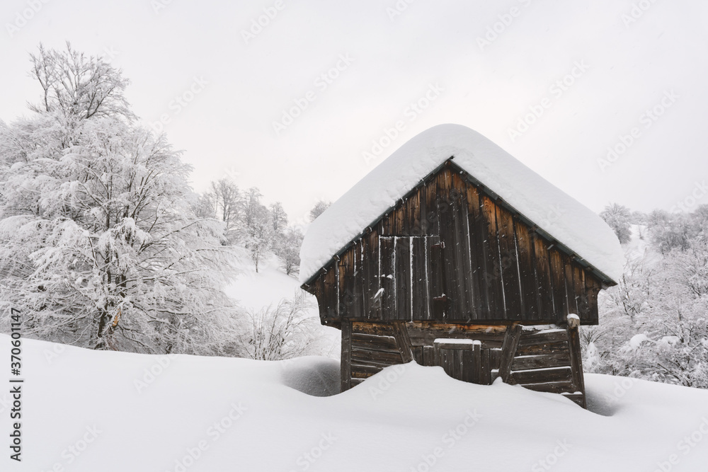 雪山木屋的极简主义冬季景观。多云，景观照片