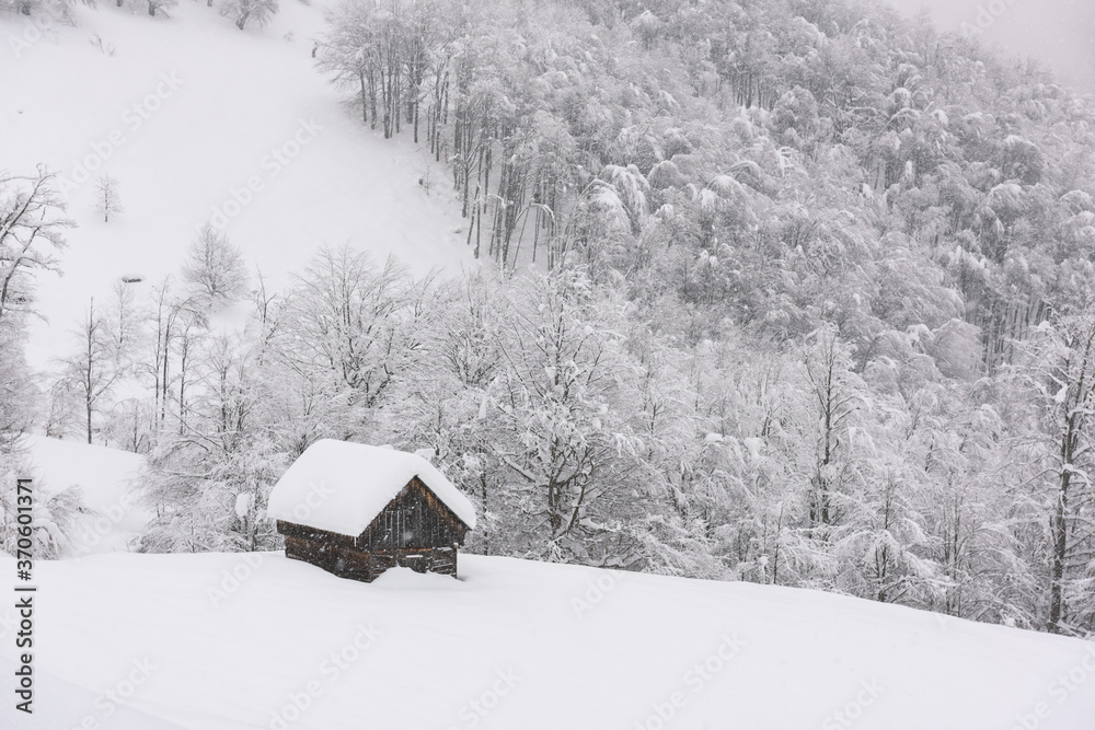 雪山木屋的极简主义冬季景观。多云，景观照片