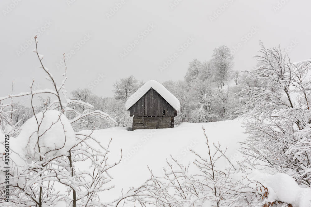 雪山木屋的极简主义冬季景观。多云，景观照片