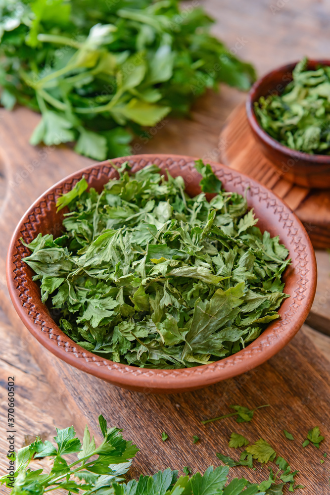 Bowl with dry parsley on table