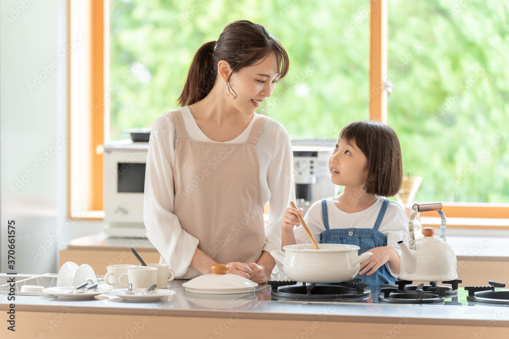 台所で料理を作るお母さんと女の子