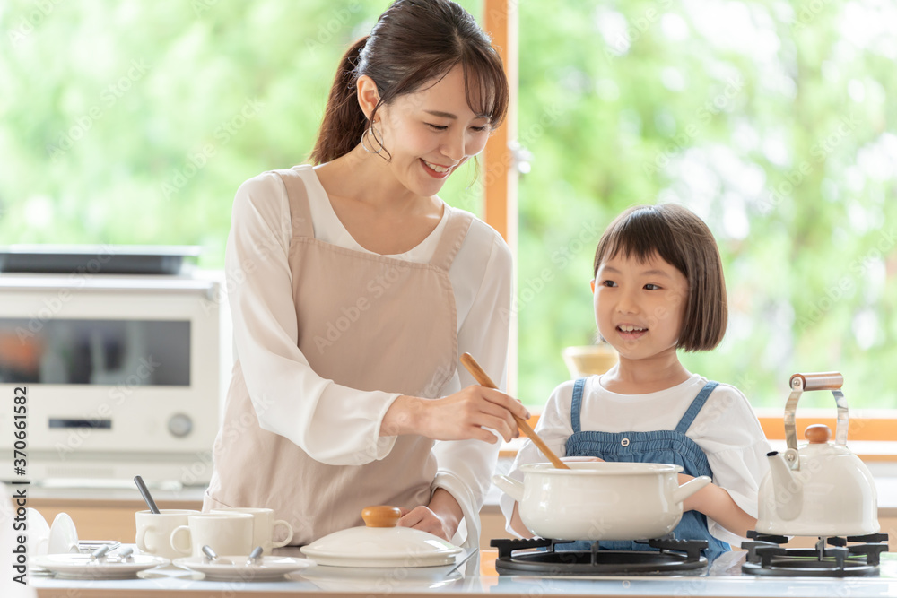 台所で料理を作るお母さんと女の子