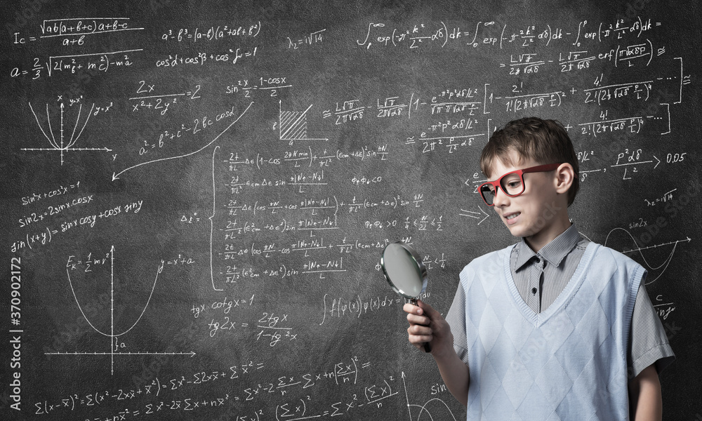 Curious school boy with magnifier