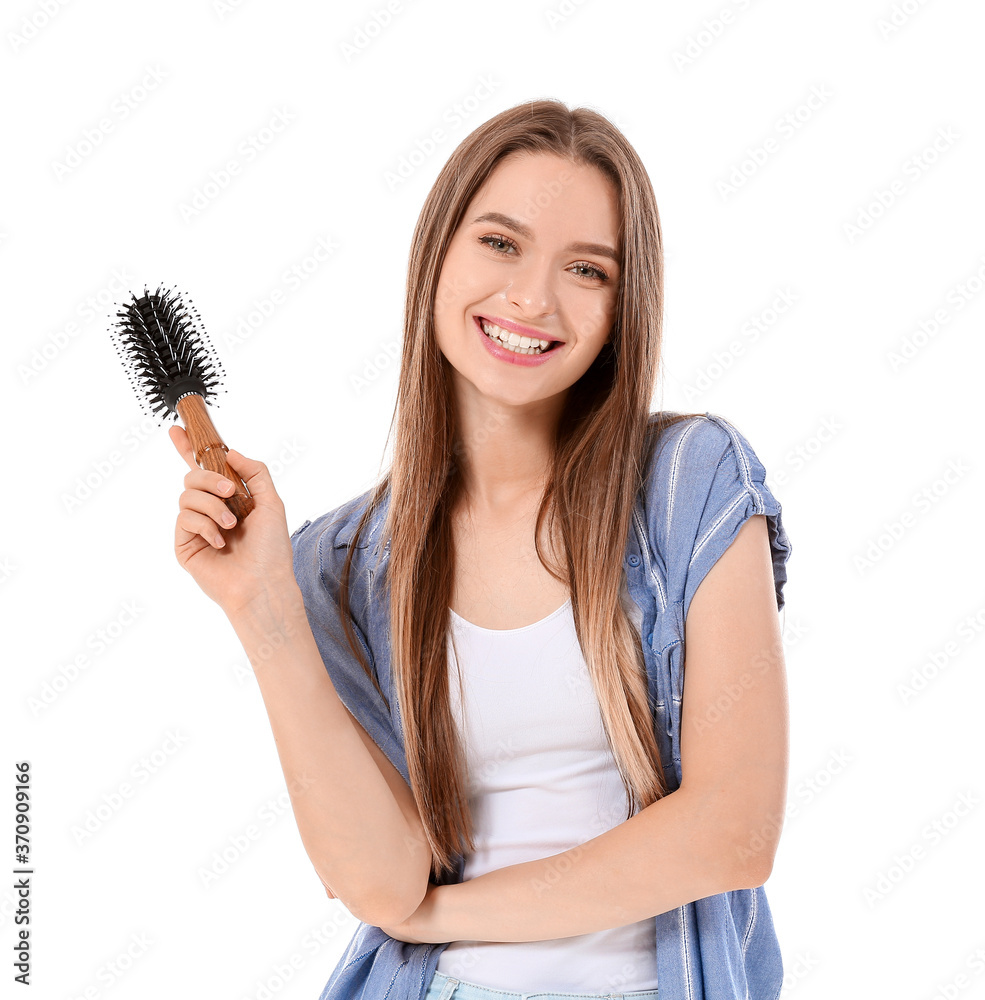 Young woman with hair brush on white background