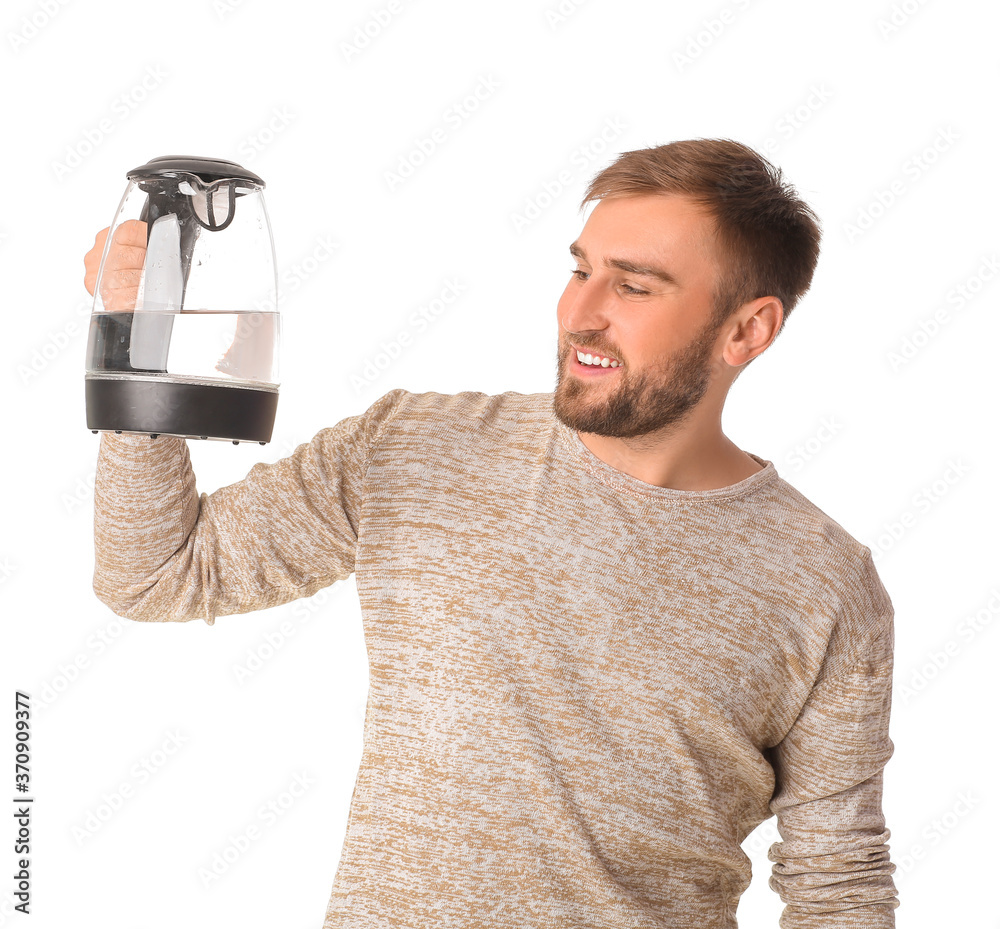 Young man with electric kettle on white background