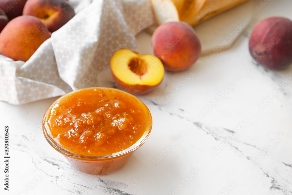 Bowl of tasty peach jam on table