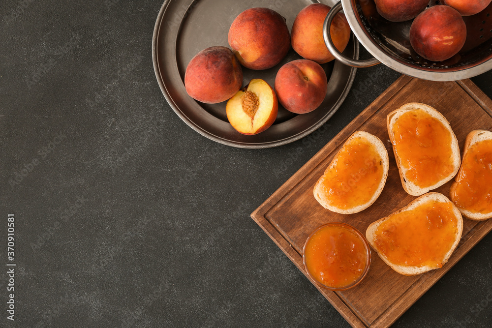 Bread slices with tasty peach jam on dark background