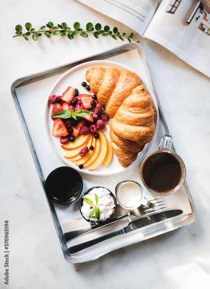 French breakfast cafe table setting. Flat-lay of breakfast with croissant, fresh berries, peach, cre