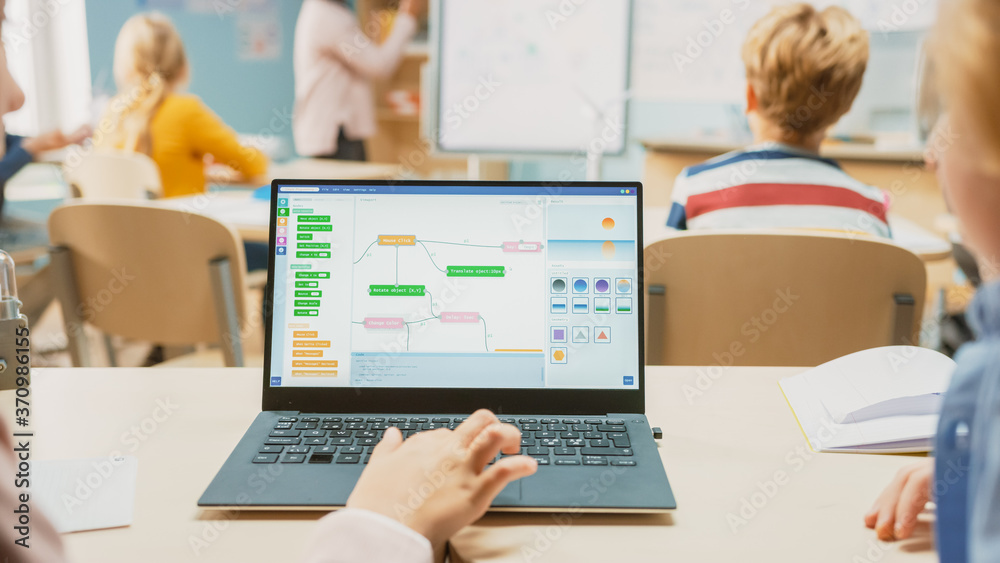 Elementary School Science Class: Over the Shoulder Little Boy and Girl Use Laptop with Screen Showin