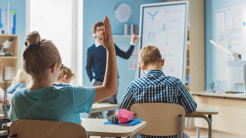 Brilliant Schoolgirl Raises Hand with an Answer. In Elementary School with Group of Bright Multiethn