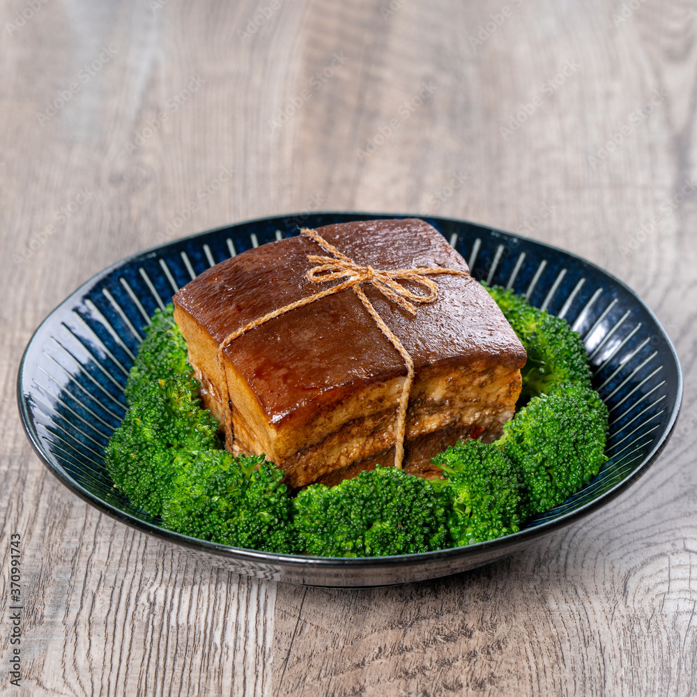 Dong Po Rou (Dongpo pork meat) in a beautiful blue plate with green broccoli vegetable, traditional 