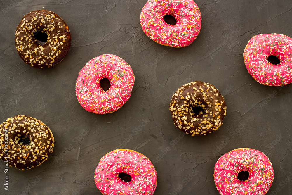 Donuts flat lay pattern on dark background, top view