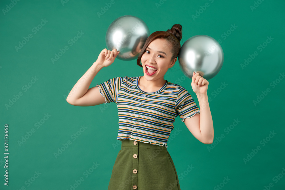 Happy female with smiling, having fun with two silver ballons.